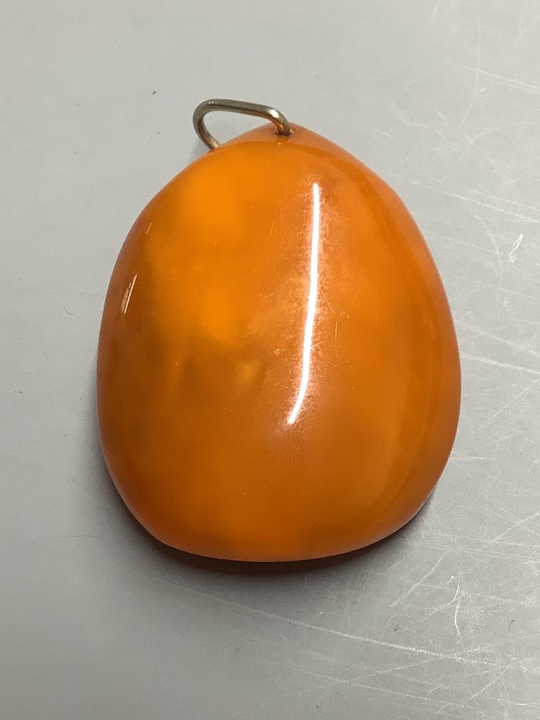 An amber pebble pendant, 56mm, gross weight 29.5 grams.